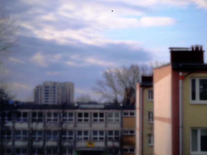 Fotografía estenopeica que muestra unos edificios borrosos.