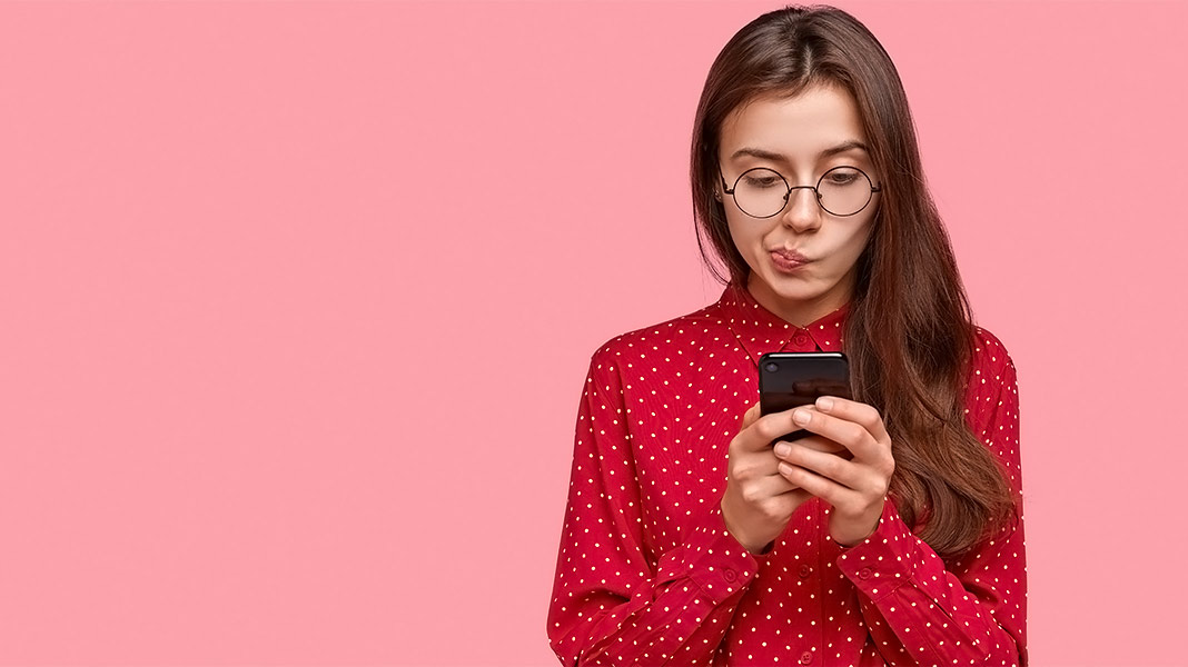 chica pensativa mirando el teléfono móvil