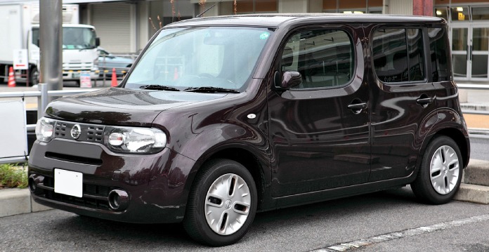 El Nissan Cube, un coche raro de color negro, similar a una mini vagoneta rectangular de ángulos fuertes.