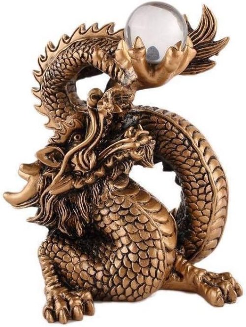 Figurilla de dragón dorado tallado sosteniendo una bola de cristal.