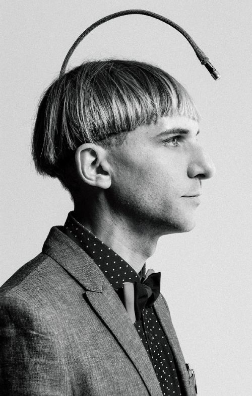 Neil Harbisson de perfil, con una antena saliendo de la parte posterior de su cabeza y que cuelga sobre su frente, demostrando que es uno de los cyborgs reales.