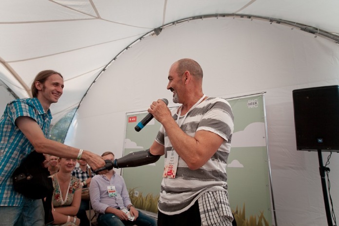 Nigel Ackland estrecha con su brazo biónico a un oyente en una conferencia.