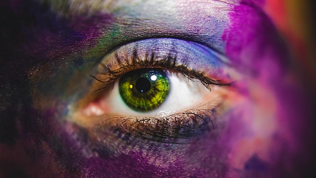 ojo de mujer con la cara pintada de varios colores