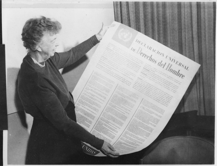 Eleanor Roosevelt posando junto con la Declaración de los Derechos Humanos Universales en español (edición de la original no realizada por este medio).