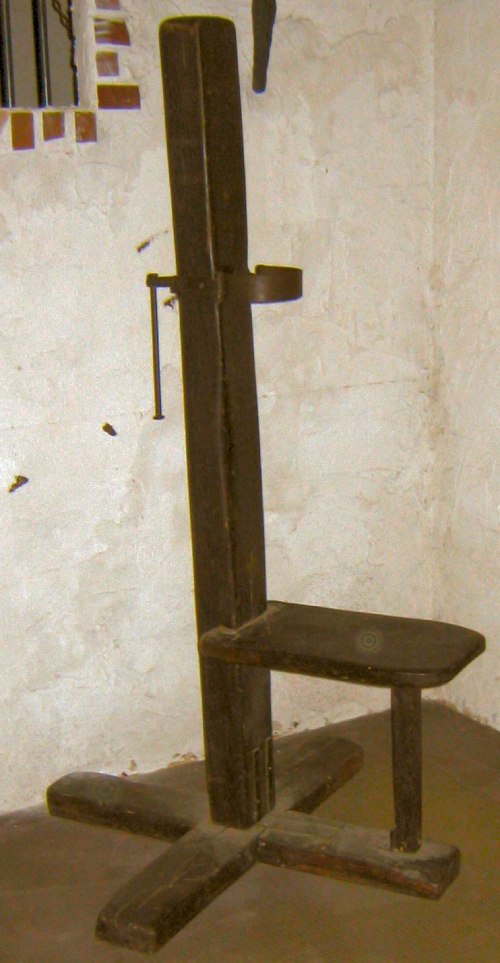 Silla de madera con un mecanismo a la altura del cuello de las potenciales víctimas.
