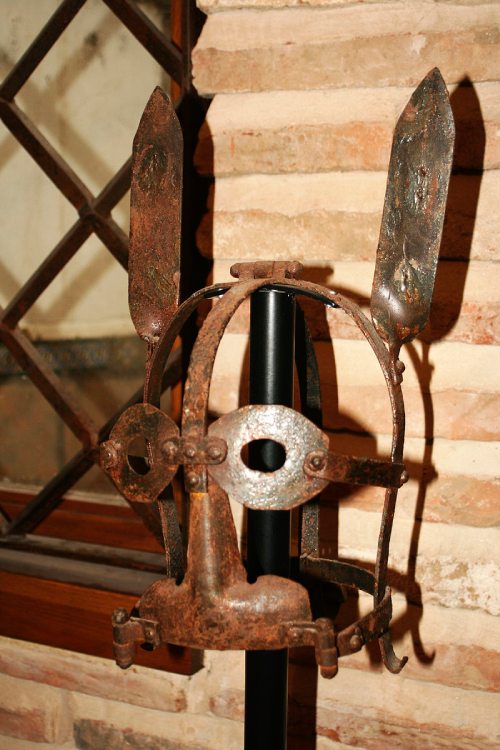 Instrumento de tortura antiguo y oxidado que consiste en una máscara de metal.